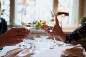 Couple toasting glasses of wine at restaurant one of most romantic things to do in Missoula