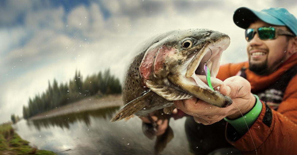 Man holding his trout catch from a day of Flathead Lake Fishing