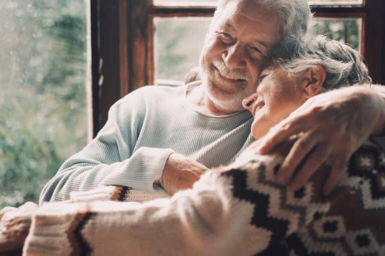 An older couple snuggles together while they consider the many things to do in Montana for couples this winter.