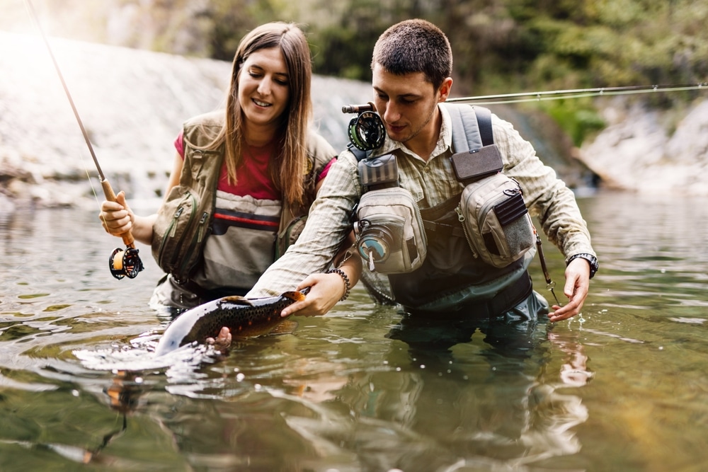 There are many things to do in Missoula, including fly fishing during your Montana getaway. Here, a couple is catching a trout.